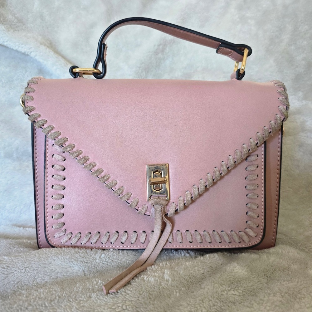 Pink handbag with strap for crossbody option.